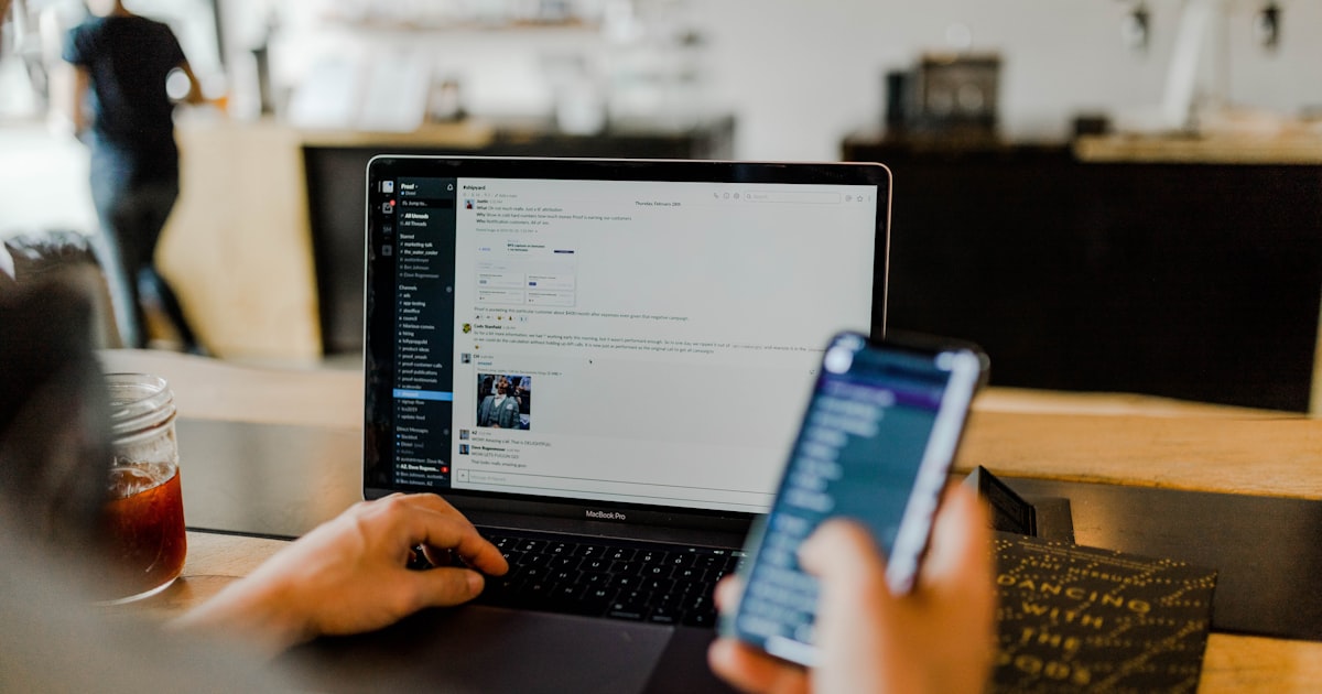 A person scrolling Instagram on a phone next to a laptop — illustrating social media advertising.